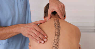Chiropractor Adjusting the Spine of Young Patient